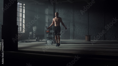 Active guy exercising on jump rope. Energetic man jumping on skipping rope
