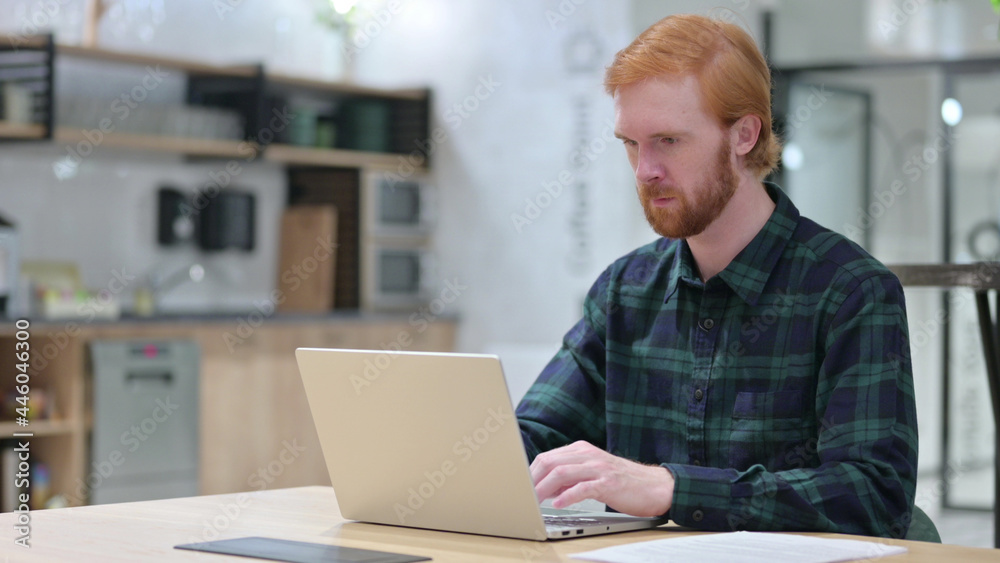 Young Redhead Man in Cafe using Laptop Young Redhead Man in Cafe using Laptop