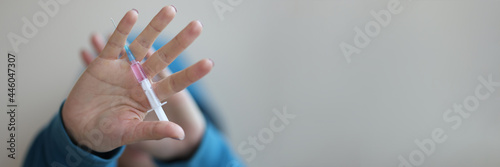 Drug syringe lying in mans hand closeup