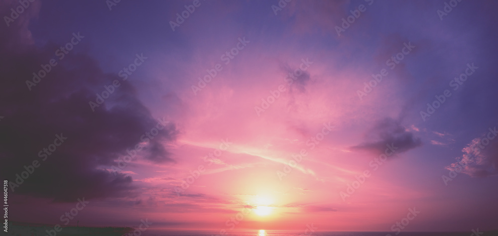 Horizontal panorama of a dramatic glowing cloudy sky at sunset. Sky texture. Abstract nature background