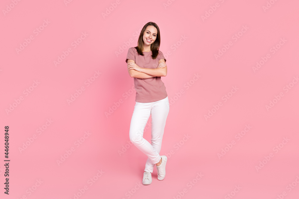 Full length body size view of attractive cheerful girl folded arms isolated over pink pastel color background Full length body size view of attractive cheerful girl folded arms isolated over pink pastel color background