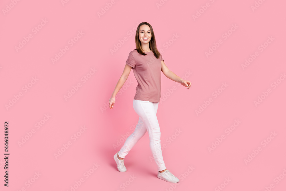 Full length body size view of attractive cheerful content slender girl walking isolated over pink pastel color background Full length body size view of attractive cheerful content slender girl walking isolated over pink pastel color background
