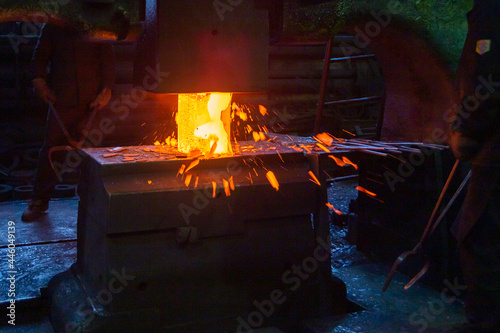 close-up picture of hot steel manual forging process with big mechanical hammer machine