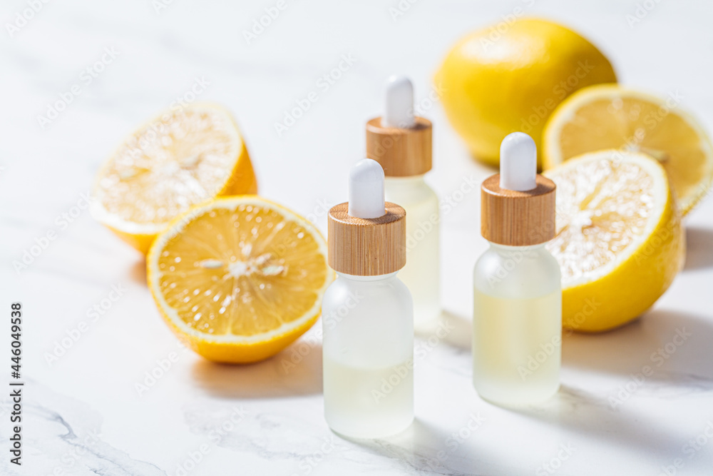 Lemon essential oil in glass bottles, white background. Skin and body care concept. Lemon essential oil in glass bottles, white background. Skin and body care concept.