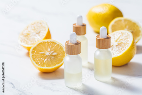 Lemon essential oil in glass bottles, white background. Skin and body care concept.