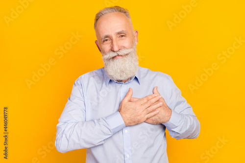 Photo of optimistic beard elder man hands heart wear blue shirt isolated on yellow color background