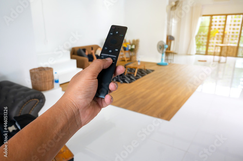 Hand hold remote control in the room.work from home concept.