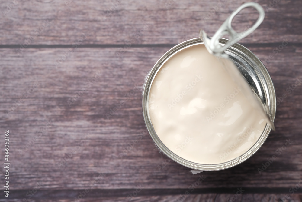 top view of milk cream in a container on wooden background, top view of milk cream in a container on wooden background,