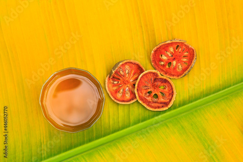 Bael juice with dried bael on a banana leaf