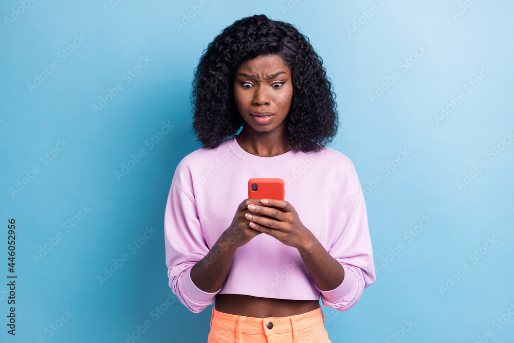 Photo portrait of unhappy woman reading fake news on smartphone isolated vibrant blue color background - obrazy, fototapety, plakaty 