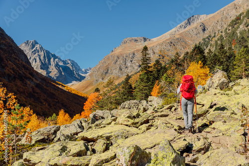 Hiker with backpack enjoying view in the autumnal mountains. Mountain and woman