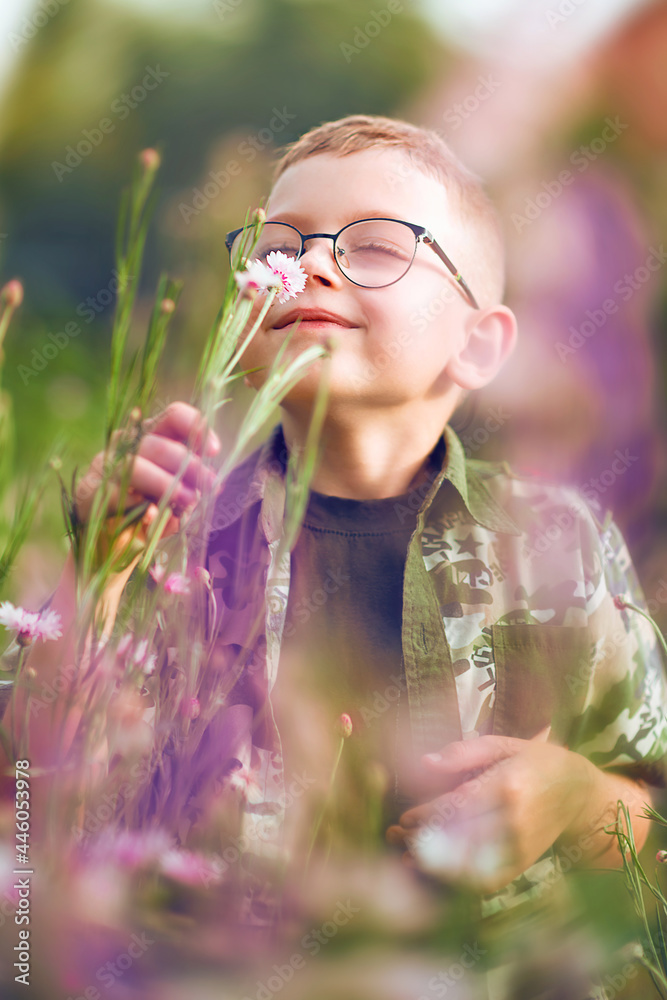 Portrait of a boy sniffing a wild flower close-up Portrait of a boy sniffing a wild flower close-up