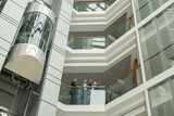 Business people standing at the balcony of modern office building and talking to each other during a meeting