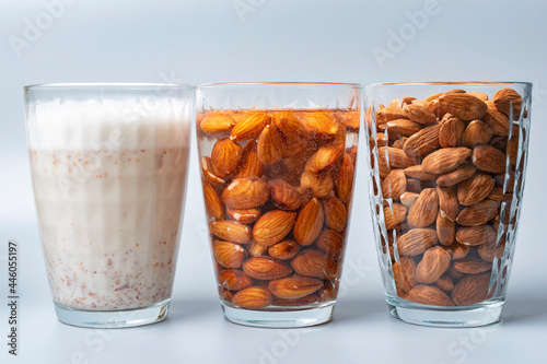 Quadro em tela Three glasses with dry, soaked almonds and with almonds milk