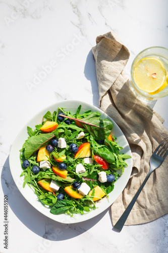 Fresh salad with nectarines, blueberries, arugula, spinach and feta cheese