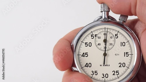 Mechanical Stopwatch in man's hand. Male hand holding stopwatch on white background. Retro analog stopwatch in a hand pointing a few seconds isolated on white background. Pushing a stopwatch button. photo