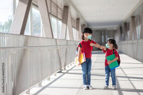 Asian sibling with face mask going back to school after covid-19 quarantine and lockdown