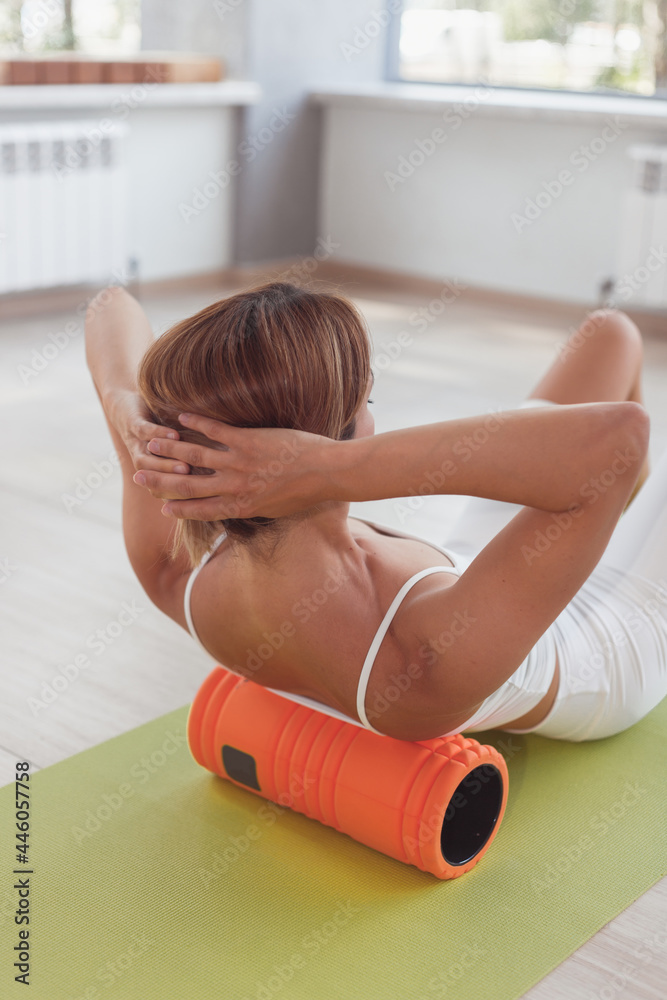 Woman doing foam roller exercises to relieve back pain