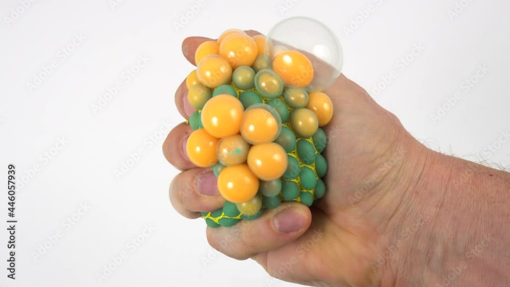 Man's hand squeezing stress ball on white. Squeezing green anti stress toy. Man's hand squeezing stress ball on white. Squeezing green anti stress toy.