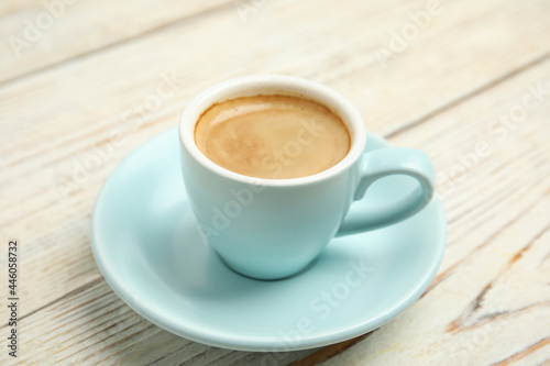 Cup of tasty coffee on white wooden table, closeup