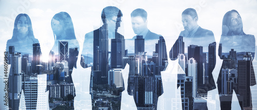 Businesspeople working together on abstract city background. Teamwork and cooperation concept. Double exposure.