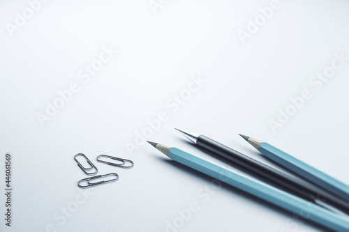 Close up of pencils and paper clips on white mock up layout workplace background, Stationery concept. 3D Rendering.