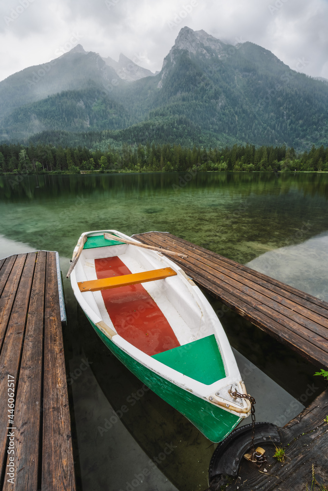 Pleasure boat at pier on Hintersee Lake with reflection of Watzmann mountain peaks. Ramsau Berchtesgaden Bavaria, Germany, Europe
