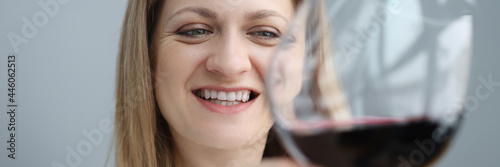 Portrait of young woman with glass of red wine in her hand