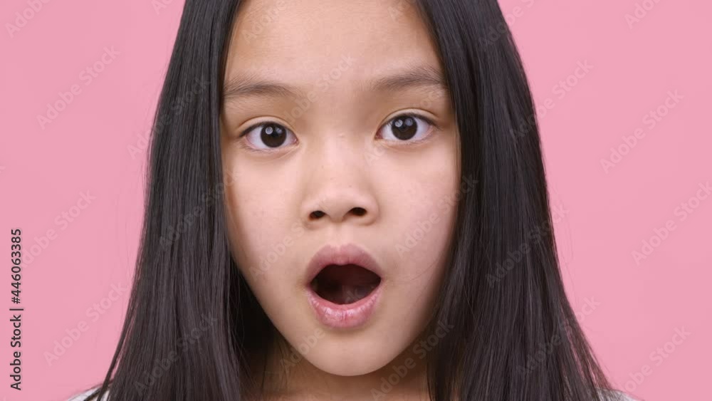 Sincere shock feeling. Amazed little girl looking at camera with open mouth, feeling shocked and amazed, pink background Sincere shock feeling. Amazed little girl looking at camera with open mouth, feeling shocked and amazed, pink background