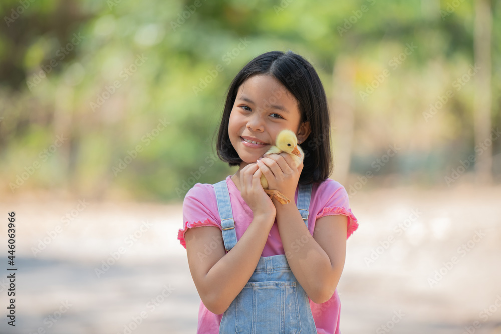 happy little girl with of small ducklings sitting outdoor. adorable little girl school age, yellow duckling in her hands, a baby's chick, Easter, spring holiday, children, love for animals.