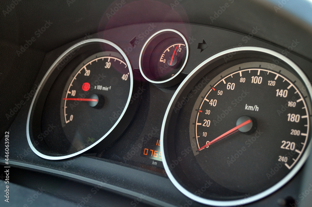 Close-up view of red speedometer hands in a car