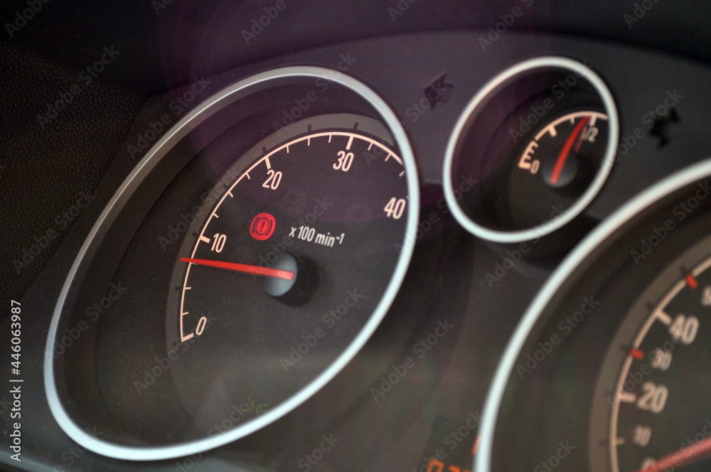 Close-up view of red speedometer hands in a car