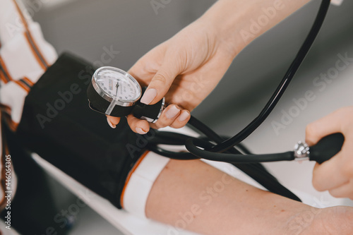 Trainee taking blood pressure of his customer in the pharmacy