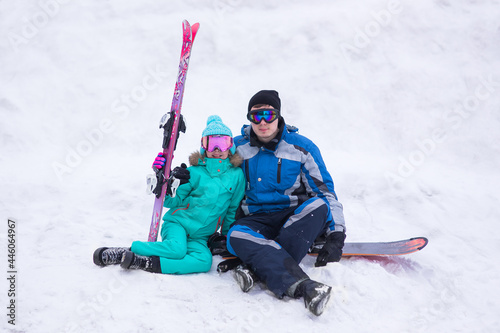 Happy couple of skier and snowboarder having fun at the ski resort. Father and daughter at the ski resort. Ski winter sports concept