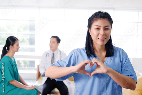 Asian surgeon doctor women are wearing blue and green surgical gown. She is Smiling and hand made heart and care for patient. Asian chief physician manMedical team in meeting room at hospital photo