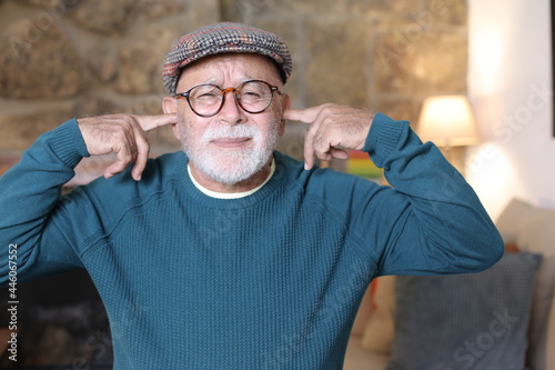 Fotografija Stubborn senior man blocking ears with fingers