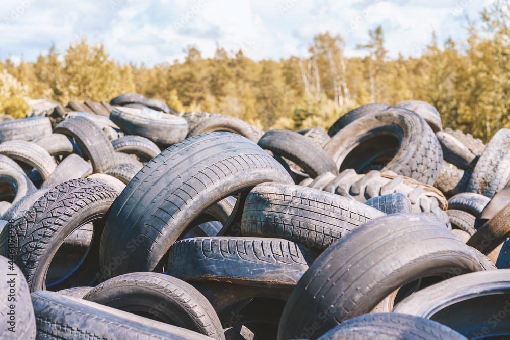 Dump of used automobile tires. Poisonous fumes into atmosphere, environmental pollution and problem of waste recycling concept Dump of used automobile tires. Poisonous fumes into atmosphere, environmental pollution and problem of waste recycling concept
