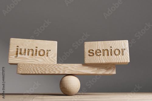 Junior and senior balance concept. Wooden cube block with word Junior and senior on seesaw. Life style concept