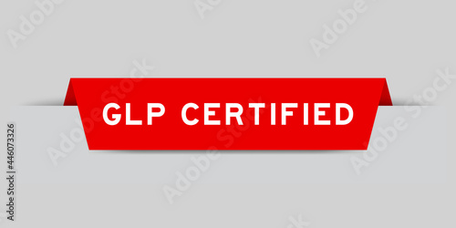 Red color inserted label with word GLP (Abbreviation of Good laboratory practice) certified on gray background