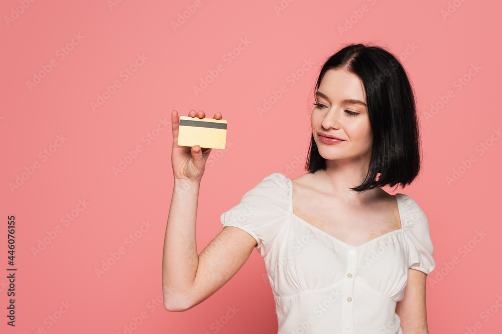 Pretty woman with vitiligo holding credit card isolated on pink Pretty woman with vitiligo holding credit card isolated on pink
