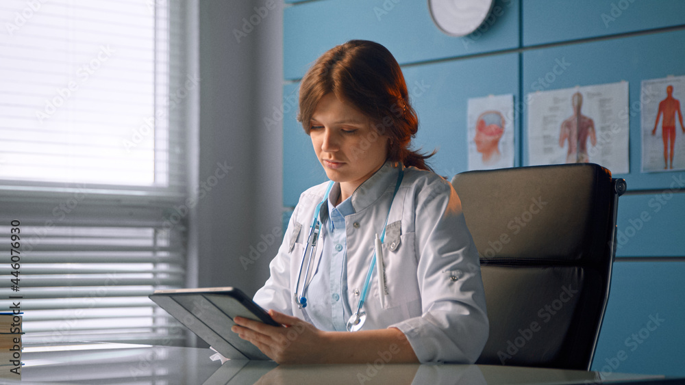 Lady general practitioner in white coat shows patient black tablet display explaining diagnostic at meeting Lady general practitioner in white coat shows patient black tablet display explaining diagnostic at meeting