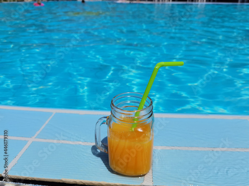 orange juice by swimming pool in summer holidays