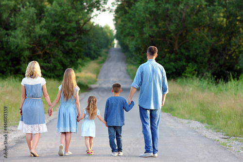 A Happy family walk along the road in the park on nature background