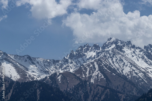 A view of the snowy peaks of the mountains  and behind them white clouds