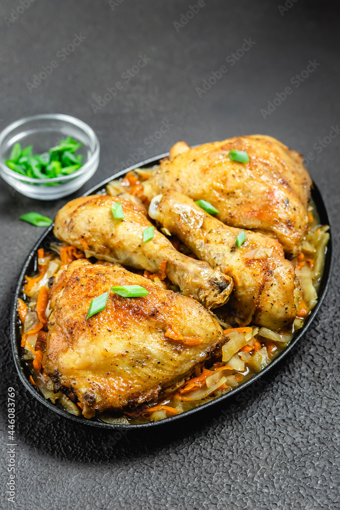Spicy roasted chicken with vegetables  on dark background. Space for text.
