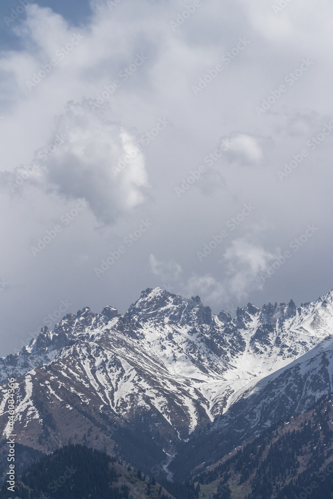 Clouds of different sizes over mountain snowy peaks Clouds of different sizes over mountain snowy peaks