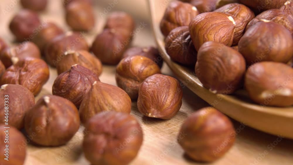 A full wooden spoon of fresh hazelnuts without the shell. Macro. Dolly shot. Organic healthy food concept. Rustic view