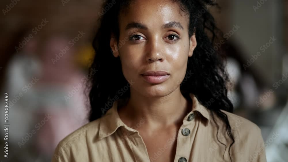 A close-up view of a beautiful Afro-American businesswomen is looking to the camera while standing in the office A close-up view of a beautiful Afro-American businesswomen is looking to the camera while standing in the office