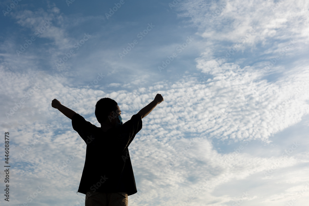 Cheerful boys celebrating and proudly outstretching his arms towards sky at stunning sunset. Cheerful boys celebrating and proudly outstretching his arms towards sky at stunning sunset.