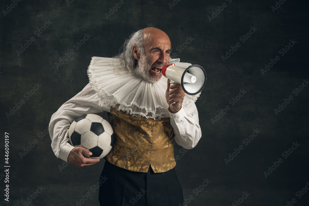 Elderly gray-haired man, actor posing with football ball isolated on dark vintage background. Retro style, comparison of eras concept. - obrazy, fototapety, plakaty 